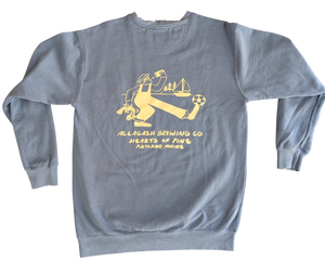 Light blue sweatshirt with yellow Maine and soccer themed graphic. Yellow text "Allagash Brewing Co. Hearts of Pine Portland, Maine"