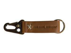 A brown leather keychain with a metal ring and snap hook, featuring an embossed logo that reads 'From Maine With Love'.