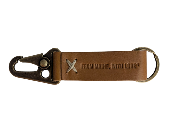 A brown leather keychain with a metal ring and snap hook, featuring an embossed logo that reads 'From Maine With Love'.