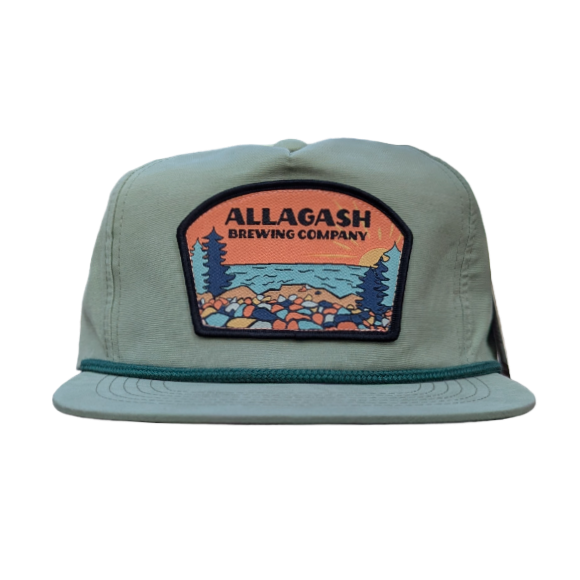 A sage green colored snapback rope hat with a structured front panel featuring a patch that includes the text "Allagash Brewing Company" at the top and depicts a coastal landscape.