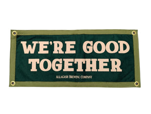 Green sign with 'WE'RE GOOD TOGETHER' text on a white background